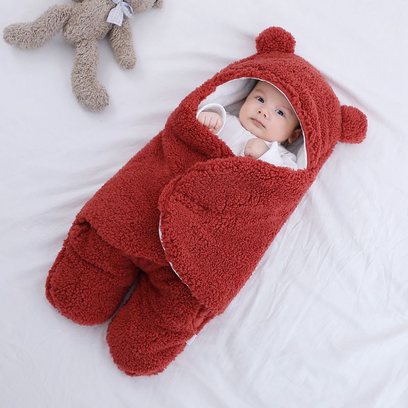 Baby in plush bear-ear hooded wrap