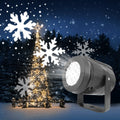 Snowflake projector lighting a house front
