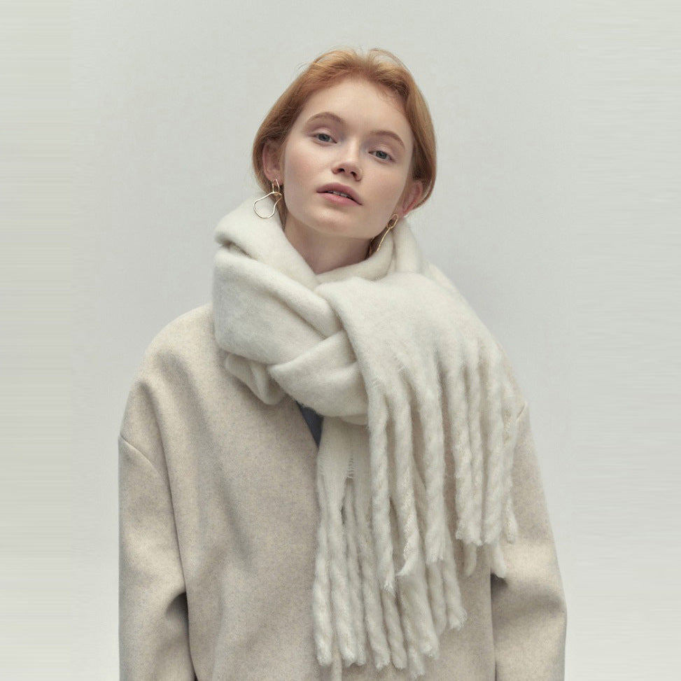Woman wearing long ivory scarf with tassels