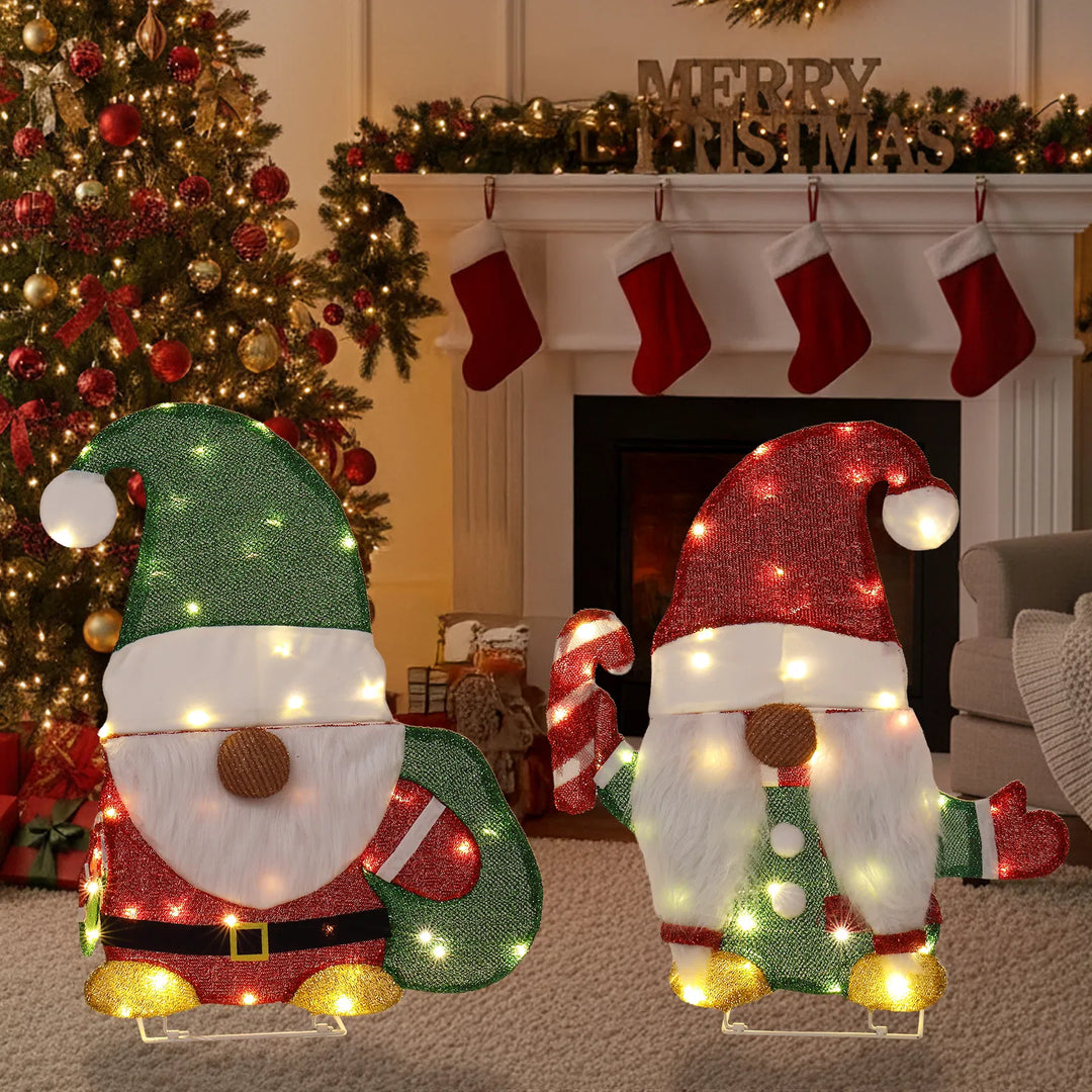 Two lit Christmas gnome figures in garden