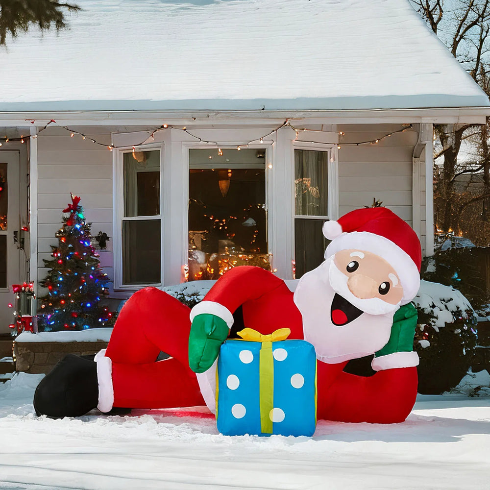 Inflatable Santa lying beside a gift box