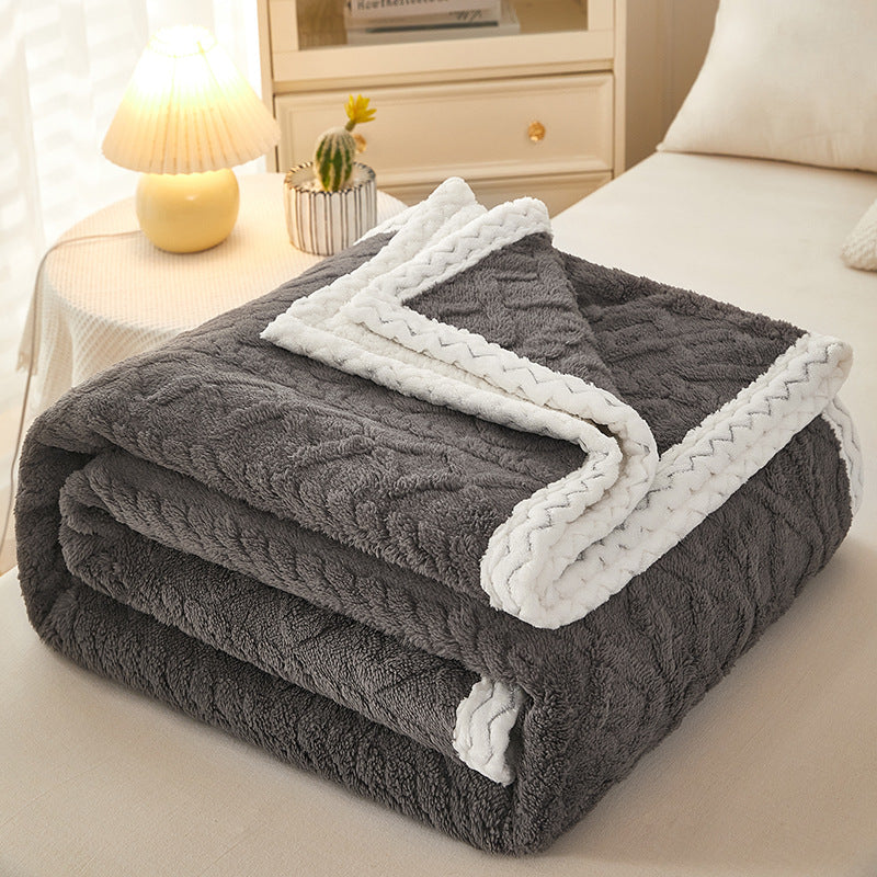 Thick sherpa fleece blanket folded on bed