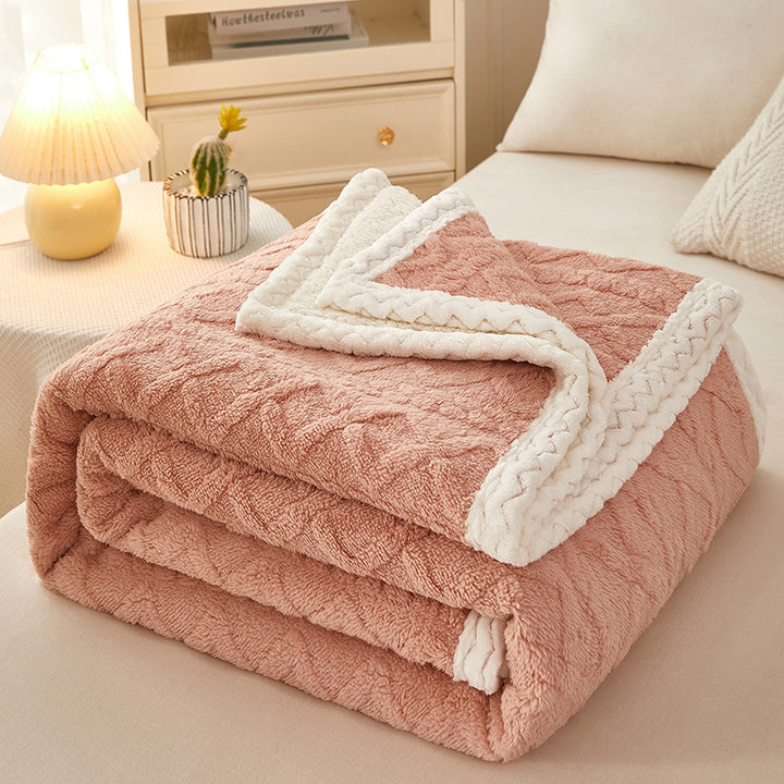 Thick sherpa fleece blanket folded on bed