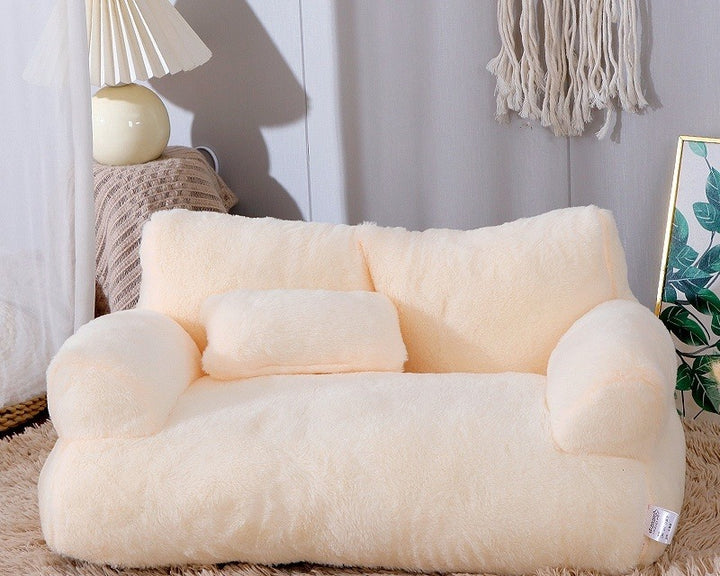Cat lying on plush pet sofa with pillow