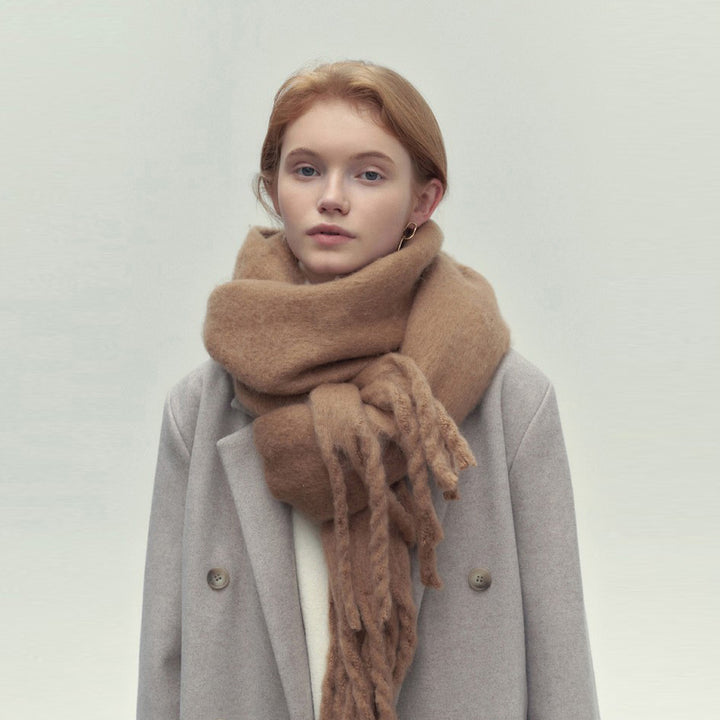 Woman wearing long ivory scarf with tassels