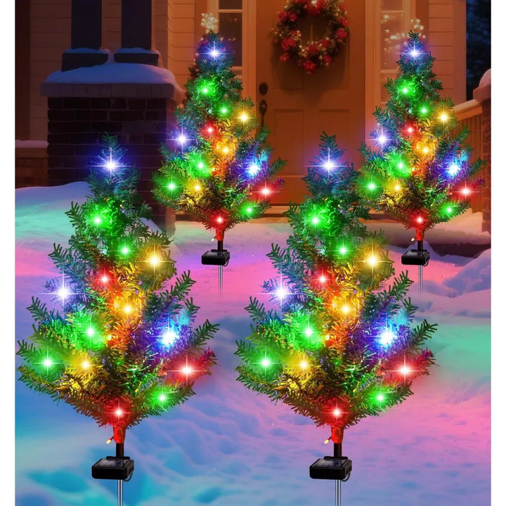 Four solar mini Christmas trees lit on lawn