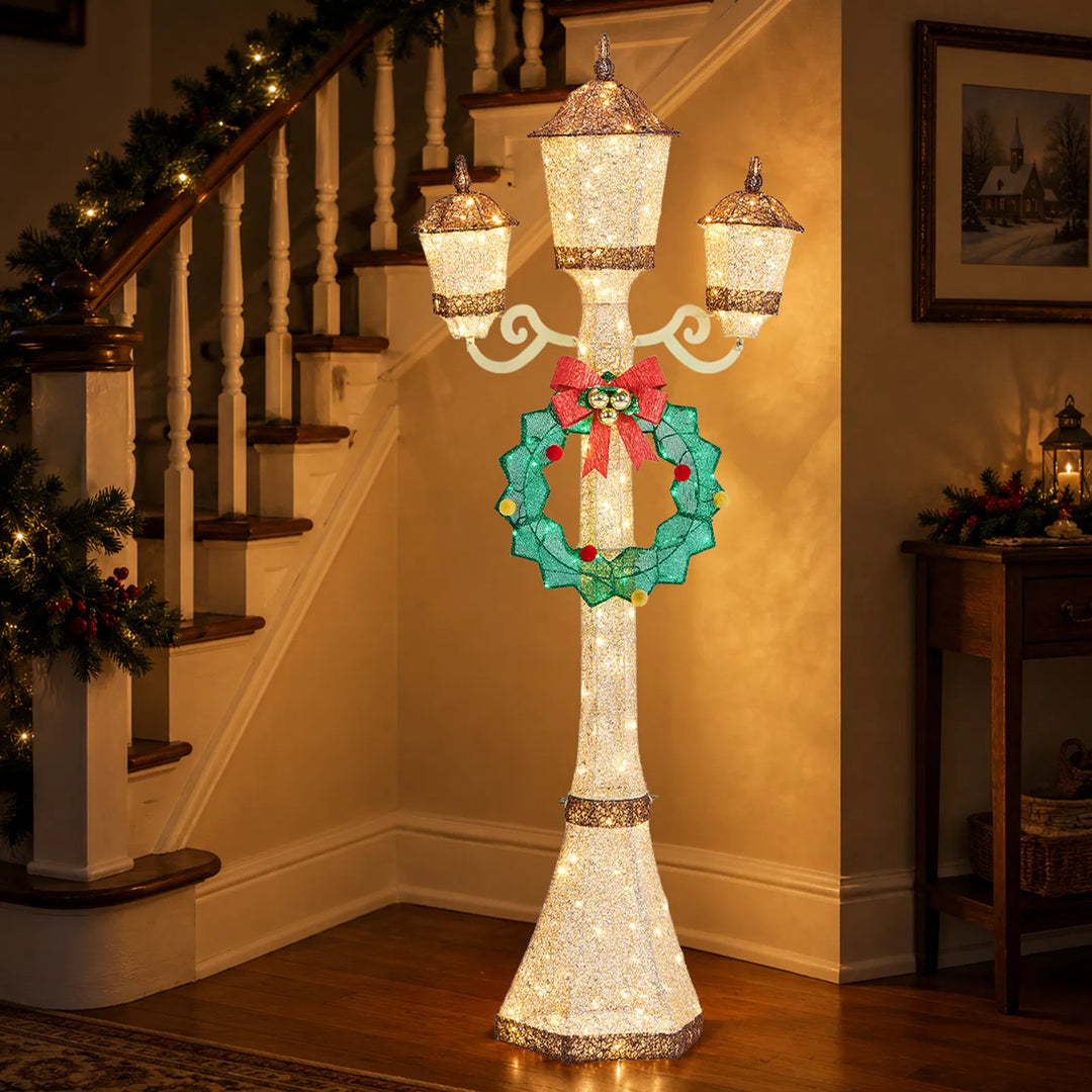Gold lit Christmas lamp post with wreath