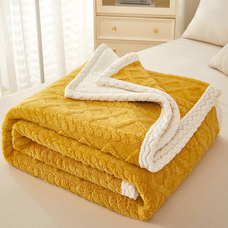 Thick sherpa fleece blanket folded on bed