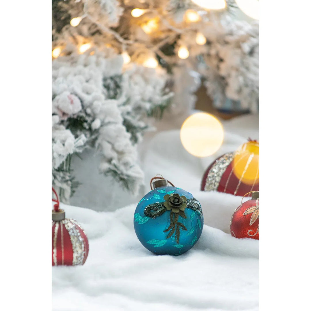 Four teal glass Christmas baubles with glitter